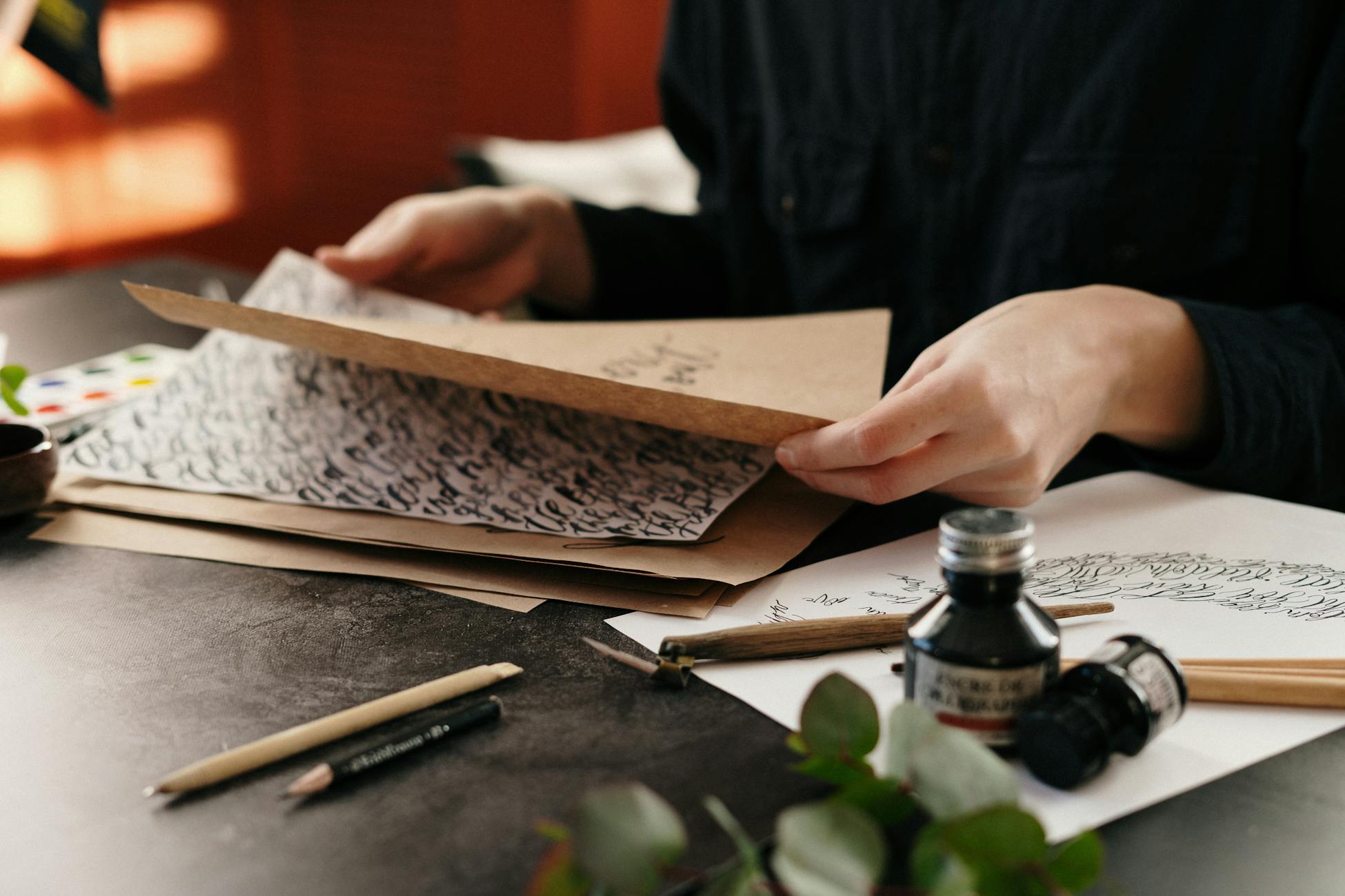 Close-up of handwritten letters and ink on a desk.