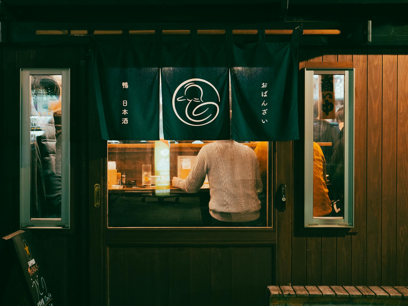 A view from outside a cozy urban café in Toyohashi, Japan, capturing the ambiance and design.