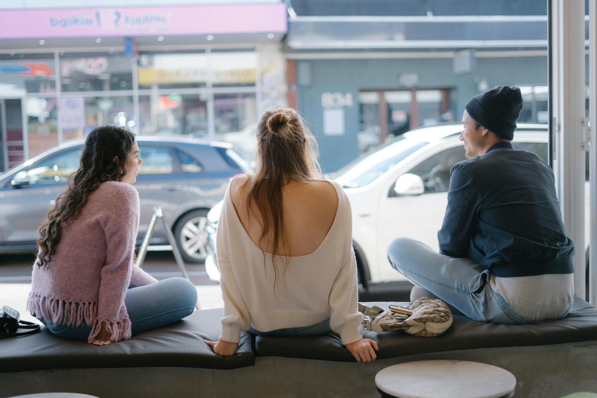 Two old friends sitting at a distance from each other in a quiet cafe.