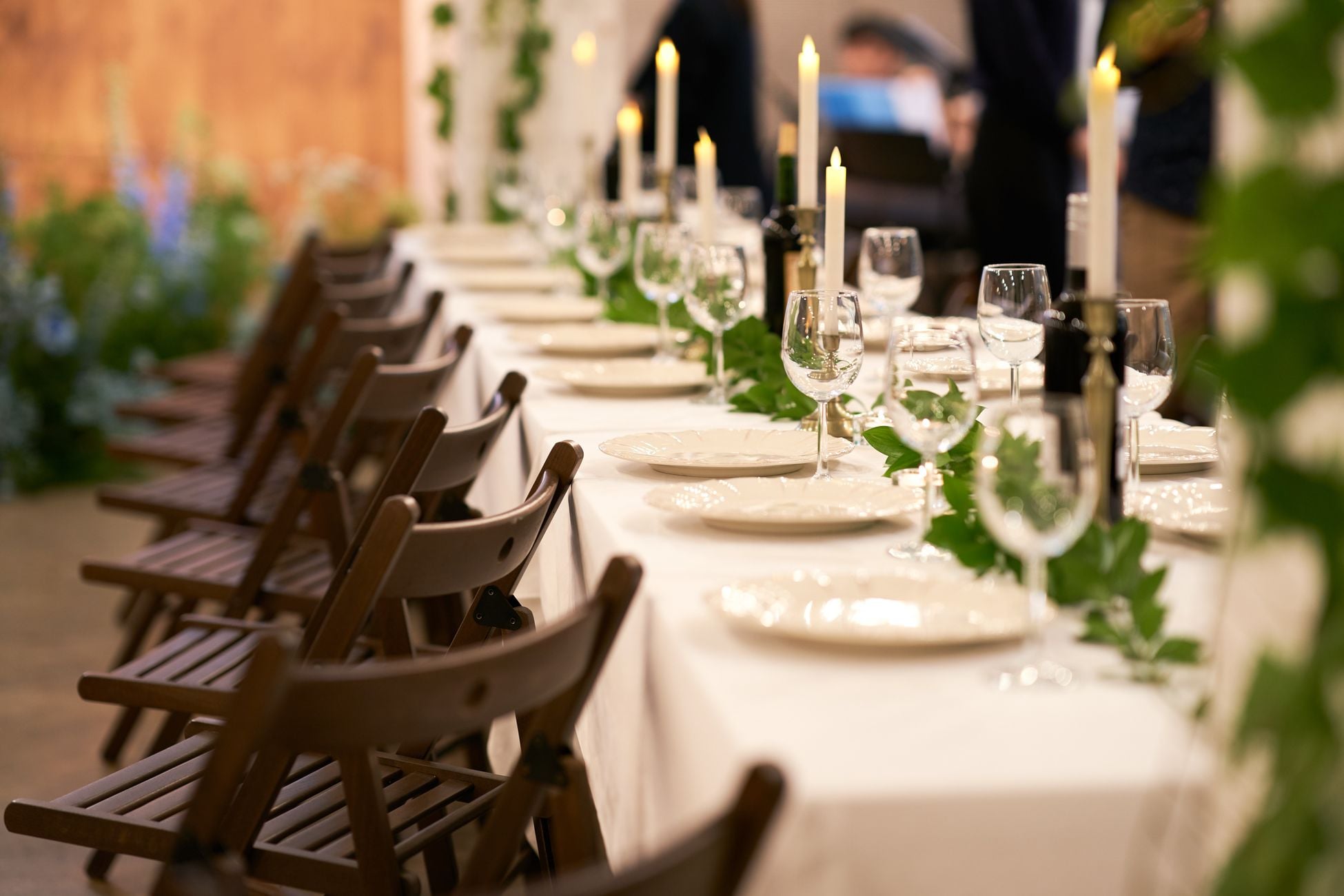A beautifully decorated banquet table with candles and greenery, creating a warm and inviting ambiance.