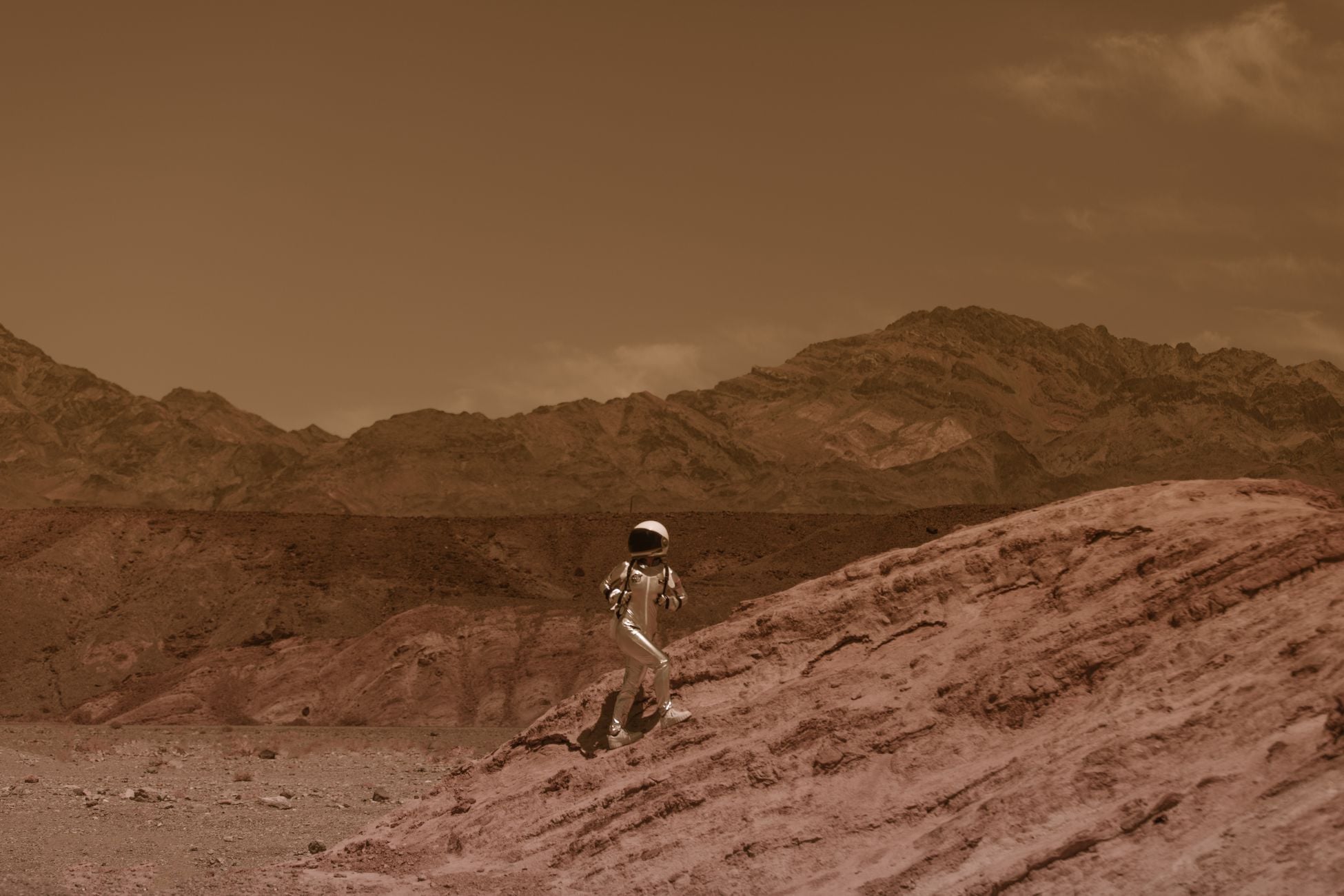 Astronaut walking on a barren landscape resembling Mars, with futuristic and adventurous vibes.